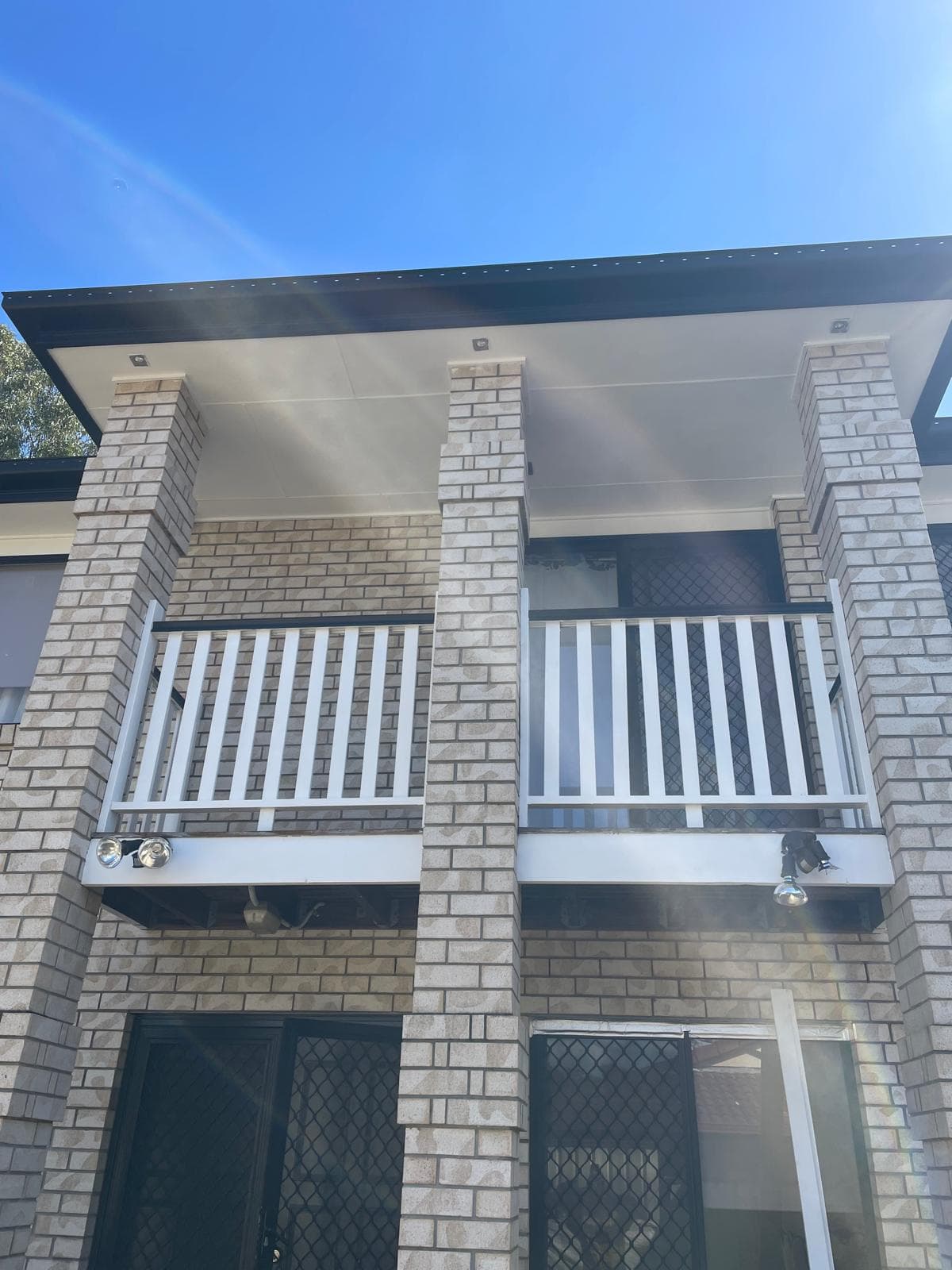 Modern brick home exterior with white balcony railings